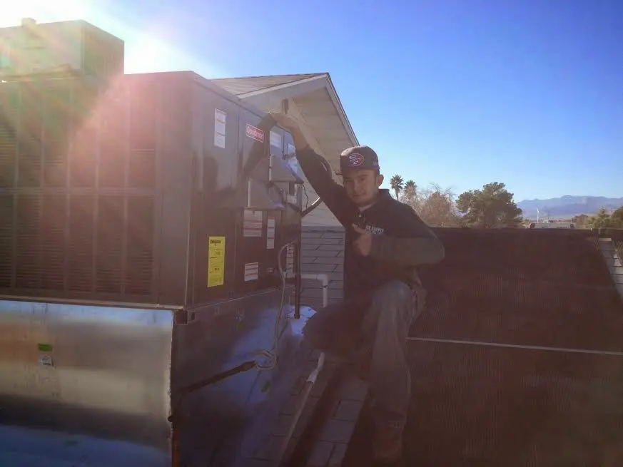 HVAC technician performing AC Tune-Up on a rooftop unit in Amsterdam